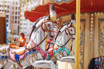 Horses on a carnival Merry Go Round. Old French carousel in a holiday park. Big roundabout at fair...