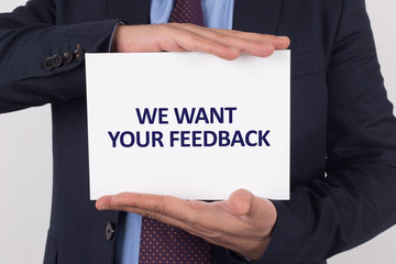 Man showing paper with WE WANT YOUR FEEDBACK text