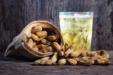 Boiled Peanuts and beer on wood background
