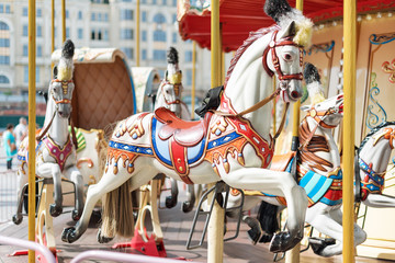 Horses on a carnival Merry Go Round. Old French carousel in a holiday park. Big roundabout at fair in amusement park. © Magryt