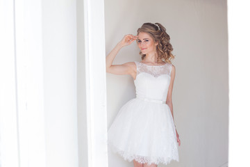 Fototapeta premium pretty girl in a short white wedding dress