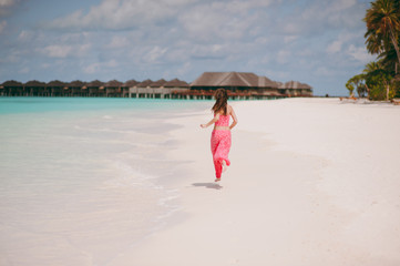 Girl in pink clothes on the beach of the island