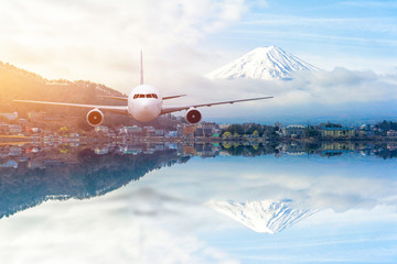Naklejka premium Airplane frying over the lake with Snow Mountain Fuji background