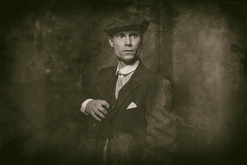Antique wet plate photo of 1920s english gangster wearing suit and flat cap.