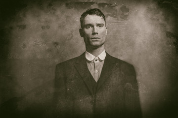 Antique wet plate photo portrait of 1920s english gangster in suit.