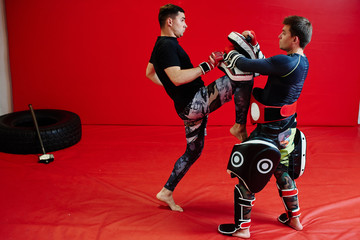 Fototapeta na wymiar Two guys martial arts exhaust strokes in the gym