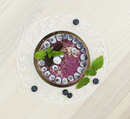 Raw vegan blueberry cake on the light wooden surface