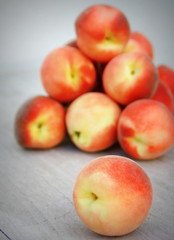 tas de pêches blanches sur fond bois,