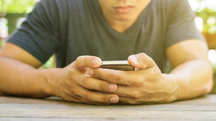 Man using a smartphone in a garden.