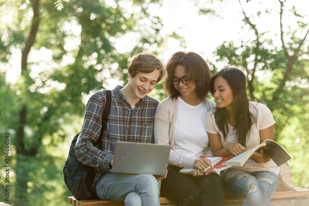 Canvas Prints Cheerful young students sitting studying outdoors