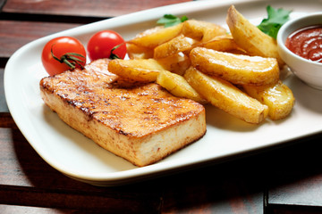 A plate of french fries with catchup, Wooden background