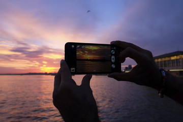 Tourist is Taking Sunset Photo with Smart Phone at The Istanbul
 - obrazy, fototapety, plakaty