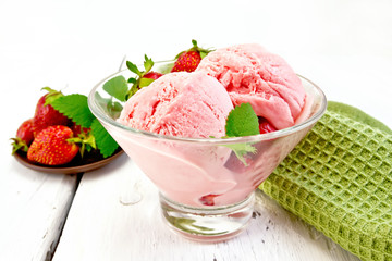 Ice cream strawberry in glass with berries on light board