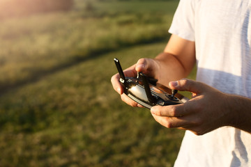 Man holds a drone remote controller in his hands. Close-up of quadrocopter RC during flight. Pilot...