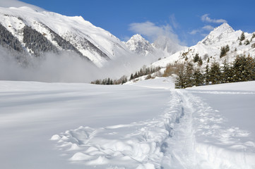 piste dans la neige traversant la montagne