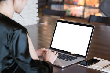 Back view asian woman freelancer working on laptop computer with white blank copy space at screen...