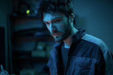 Bearded man mechanic in garage.Man in a robe,notebook,laptop,man on service station,worker