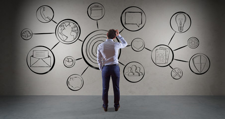 Businessman watching multimedia interface sketch on a wall 3D rendering