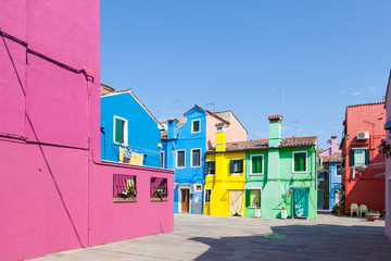 Burano, Venice, Italy. Cluster of brightly colored  cottages  in the fishing  village around a small square in morning light