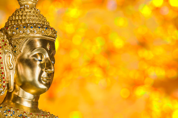 Head of golden Buddha Image with bokeh blurred background
