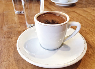 Closeup cup of coffee and water on table