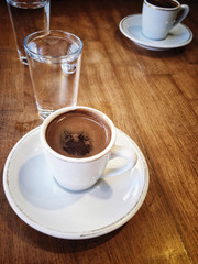 coffee cups and water on wooden table