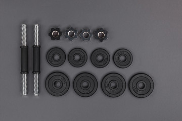 top view of various metal barbells and weight plates isolated on grey