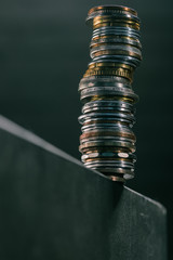 close up view of stack of different coins standing on edge of table