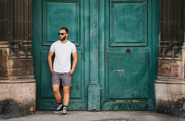Hipster handsome male model with beard wearing white blank t-shirt with space for your logo or...