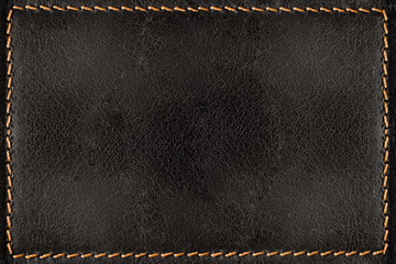 Black leather texture background with orange seams