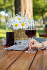 Cropped picture of women sitting outdoors in park drinking wine