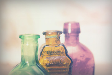 Obraz na płótnie Canvas Coloured glass bottles on a rustic background