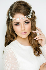 Beautiful model with an elegant hairstyle. Girl with fashion hairstyle for wedding and gentle makeup on white background