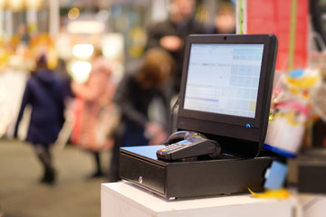 Fototapeta premium Close up of empty cash desk with computer screen and card payment terminal in small store
