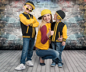 A young mother and two young sons in the style of hip hop.Fashionable family.