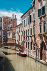 View on a venetian canal with ancient buildings and bridge in Venice