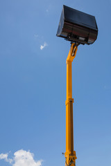Bucket loading machine on blue sky background