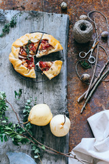 Galette with prosciutto and pear on a wooden background