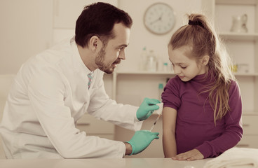 Obraz na płótnie Canvas Male doctor injecting little patient