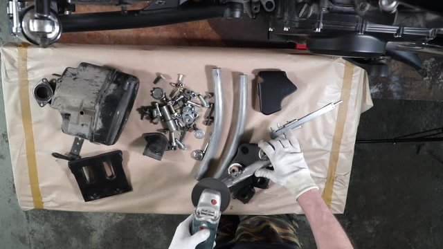 build a custom motorcycle. a mechanic works on the table. slow motion