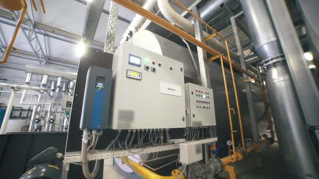 Interior industrial gas boiler with a lot of piping, pumps and valves. Modern boiler room equipment for heating system. Pipelines, water pump, valves. Engine room. Technical equipment.