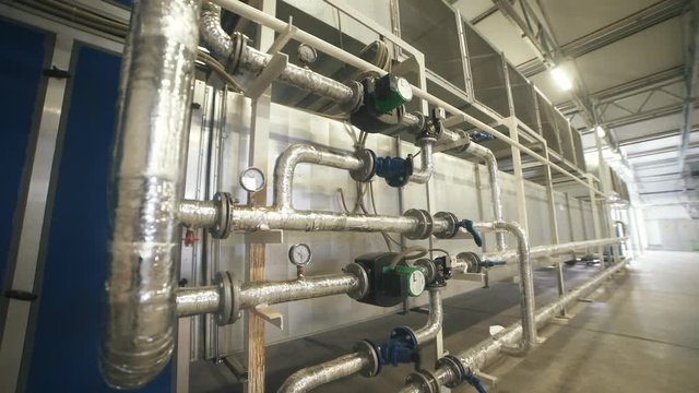 Interior industrial gas boiler with a lot of piping, pumps and valves. Modern boiler room equipment for heating system. Pipelines, water pump, valves. Engine room. Technical equipment.