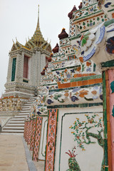 Close-up decoration ornament pattern details of famous buddhist stupa - Temple of Dawn, Wat Arun, Bangkok, Thailand. Showing glass and ceramics elements combination in Thai style on the pagoda base