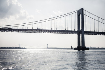 New York City bridges over river with sailboat in distance