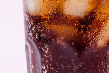 Bubbles and fizz. A cool glass of cola drink with ice