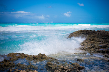 Waves crashing on rocky shore during the day on a bahmian island