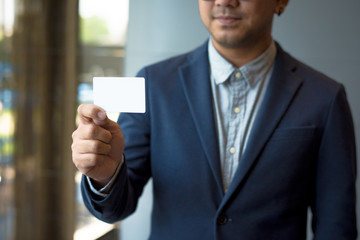 Man holding white business card,Man wearing blue shirt and showing blank white business card. Blurred background. Horizontal mockup, Smart asian business Person Professional Occupation cheerful