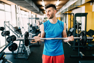 Fototapeta na wymiar Young attractive man doing exercises in gym