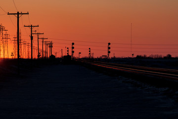 Fototapeta na wymiar Telephone Poles and Railway Tracks at Sunset