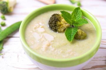 Broccoli and green peas puree soup decorated with mint
